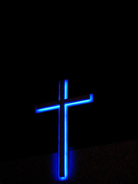 a blue cross lit up in the dark