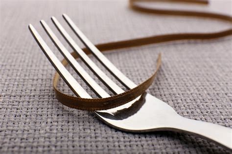 Premium Photo | Stages of tying bow on fork closeup