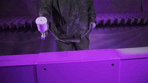 Expert is using a spraying gun to paint metal pieces at a painting factory facility. Clip ...