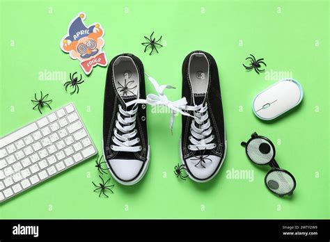 Shoes with tied together laces, computer keyboard and mouse on green ...