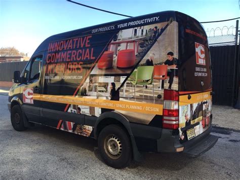 a bus with advertising on the back parked in a parking lot