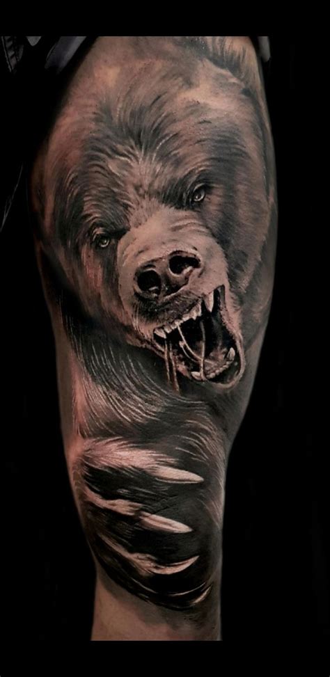 a man's leg with a bear tattoo on it, and his face is shown