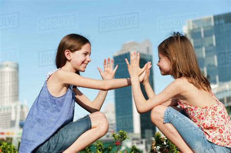 Girls playing pattycake - Stock Photo - Dissolve