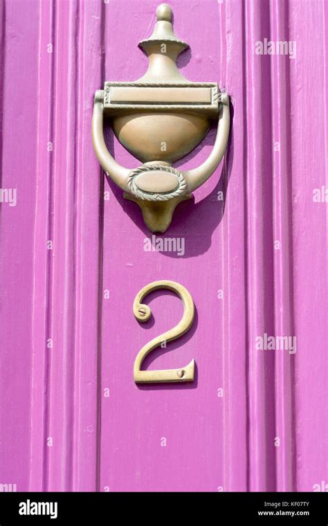 House number 2 sign and brass door knocker on door painted pink Stock ...