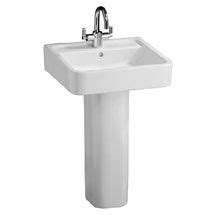 a white pedestal sink with chrome faucet