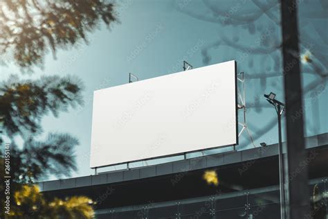 An empty huge poster mockup on the roof of a mall; white template placeholder of an advertising ...