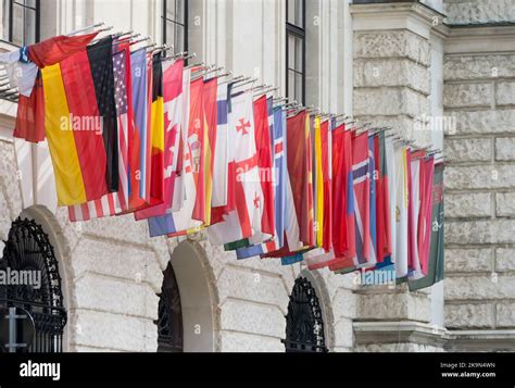 Close-up of a historical facade with mounted in a row different country flags flags of various ...