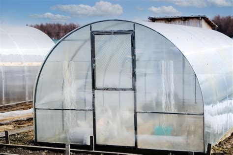 Premium Photo | A small greenhouse with a metal frame covered with polycarbonate for growing ...