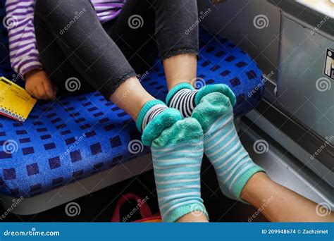 Two Kids on a Train Wearing Striped Socks Putting Their Feet Together ...