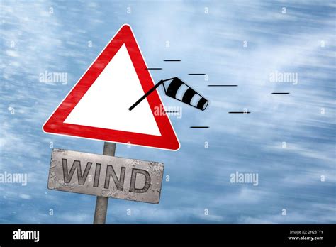 Wind warning sign getting blown away by a storm Stock Photo - Alamy