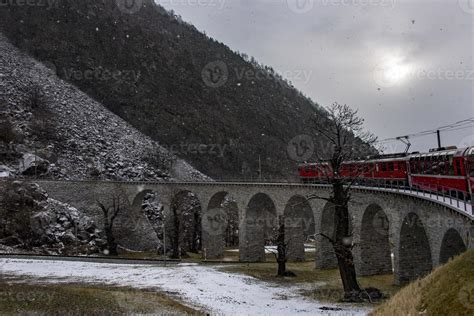 Red train in the snow in swiss alps 11968201 Stock Photo at Vecteezy