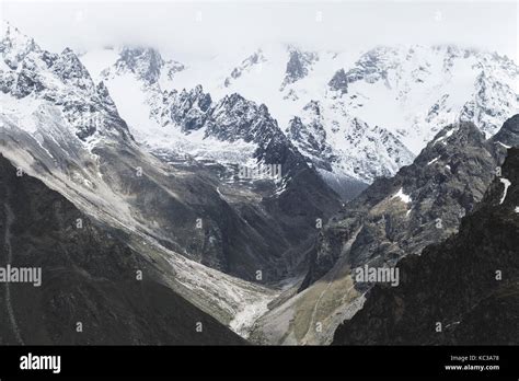 Snow mountain peaks of Caucasus mountains in cold cloudy weather ...