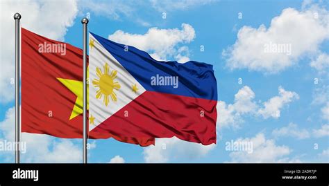 Vietnam and Philippines flag waving in the wind against white cloudy ...