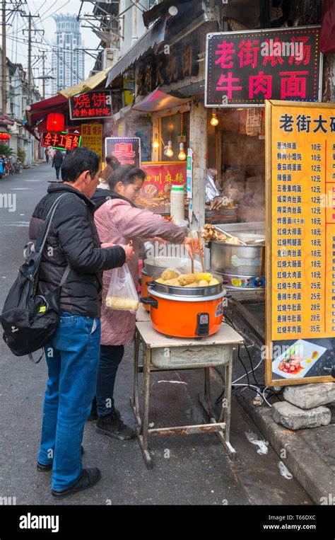 Shanghai, street food. Couple buying food at a traditional food stall ...