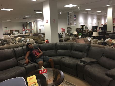 a man sitting on top of a couch in a store