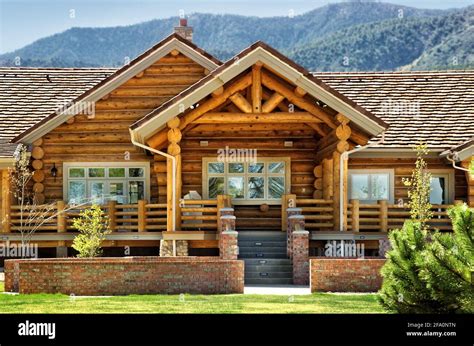 A exterior view of a modern log cabin, with a patio area, and contemporary landsaping Stock ...