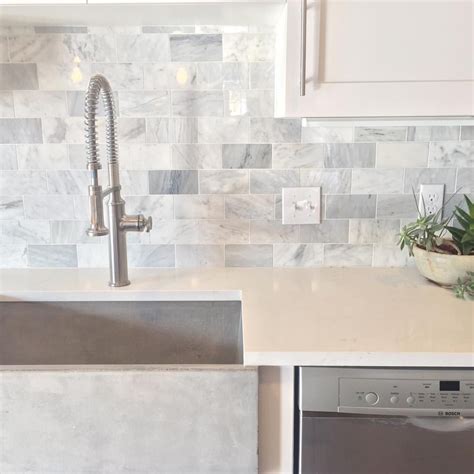 Clean modern luck with marble subway tile backsplash, and quartz countertops And a cement sink