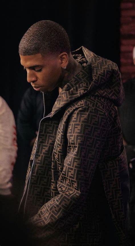 a young man is listening to music on his headphones while standing in front of other people