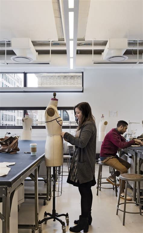 a woman standing in front of a mannequin on a table next to another person