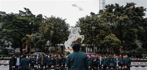 a group of people standing in front of a statue