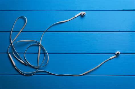 Premium Photo | White headphones on a blue wooden table background