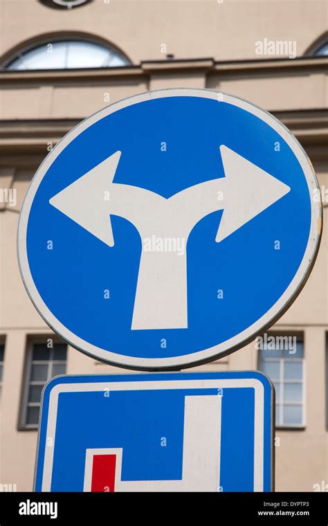 Blue Two Directions Traffic Sign in Urban Setting Stock Photo - Alamy