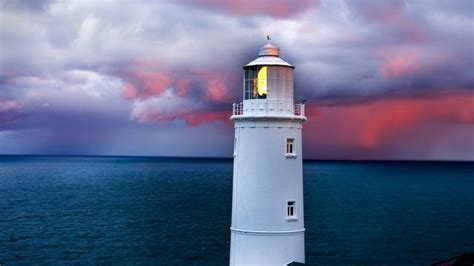 Trevose Head lighthouse under cloudy sky at sunrise, Cornwall, England ...