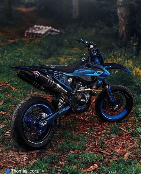 a blue dirt bike parked in the grass