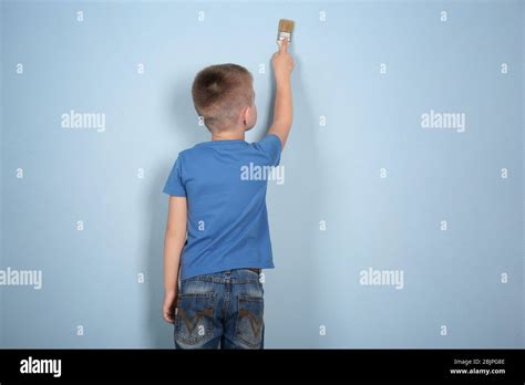 Cute little boy painting wall Stock Photo - Alamy