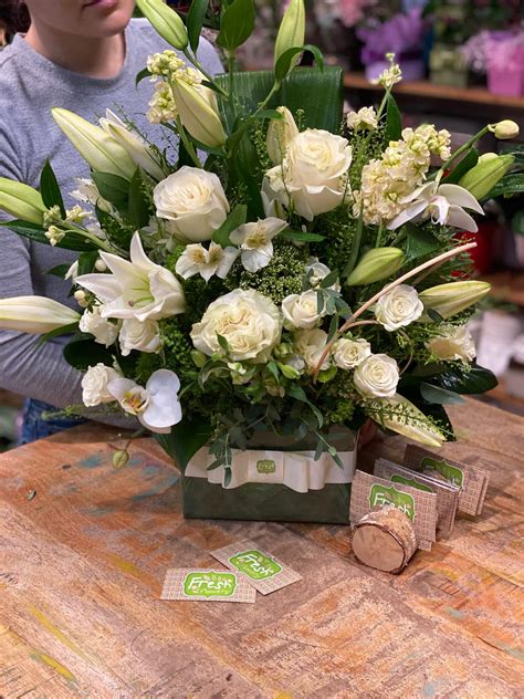 Sympathy flower arrangement with lilies in a box.