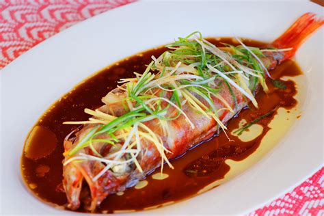 a white plate topped with fish covered in sauce