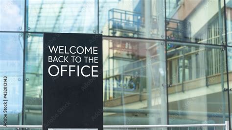 Welcome back to the office on a city-center sign in front of a modern office building Stock ...