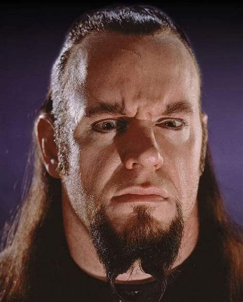 a close up of a man with long hair and beard wearing a black shirt ...