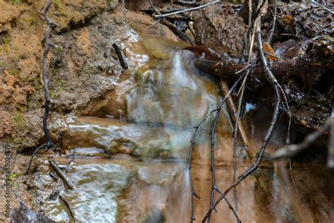 underground spring water flows on the sandstone rock wall. Long ...