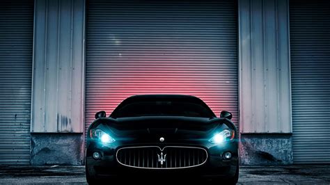 Download A Black Maserati Parked In Front Of A Garage Wallpaper | Wallpapers.com