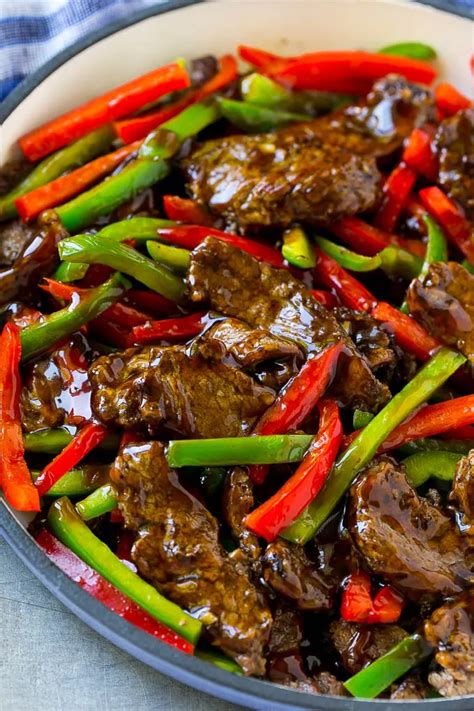 Pepper steak stir fry with thinly sliced steak and red and green bell peppers in a savory sauce ...