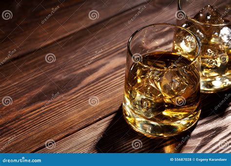 Glasses of Whiskey with Ice on Wood Stock Photo - Image of gold, wooden: 55687028