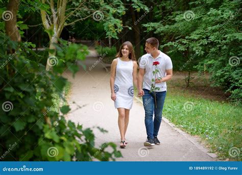 Young Man and Woman are Walking in the Park Holding Hands Stock Photo - Image of girl, feelings ...