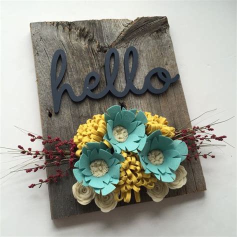 a wooden sign that says hello with flowers on it