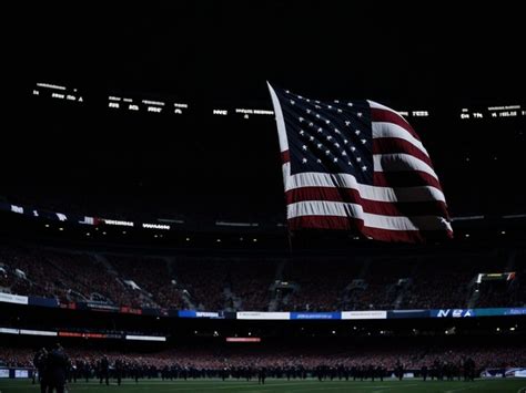 Premium AI Image | A large american flag is flying in a stadium.