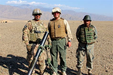 U.S. Army Lt. Col. Acevedo, left, a civilian contractor and an Afghan soldier pose for a ...