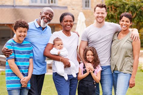 Portrait Of Smiling Multi-Generation Mixed Race Family In Garden At ...