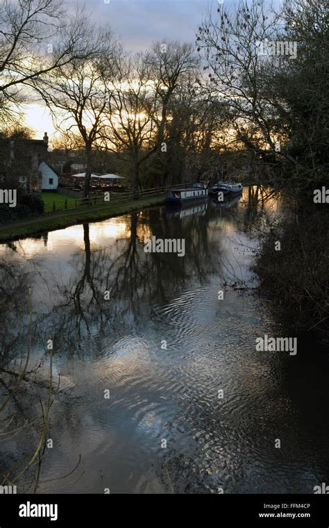 Canal flowing with a beautiful sunset behind the Cunning Man, Burghfield, Reading, Berkshire, UK ...