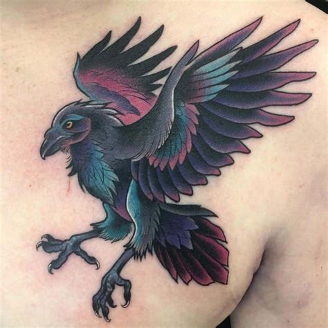 a bird tattoo on the back of a woman's shoulder, with purple and blue ...