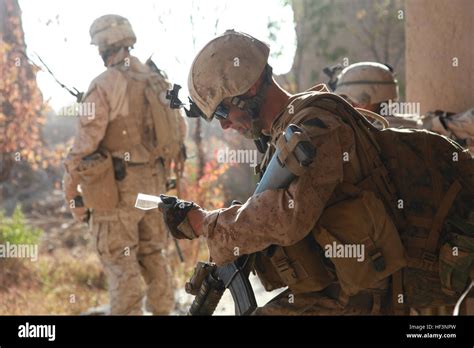 U.S. Marines with Lima Company, 3rd Battalion, 4th Marine Regiment stop to read a map during ...