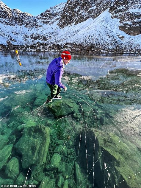 Incredible moment outdoor instructor and his wife skate across frozen, translucent lake in ...