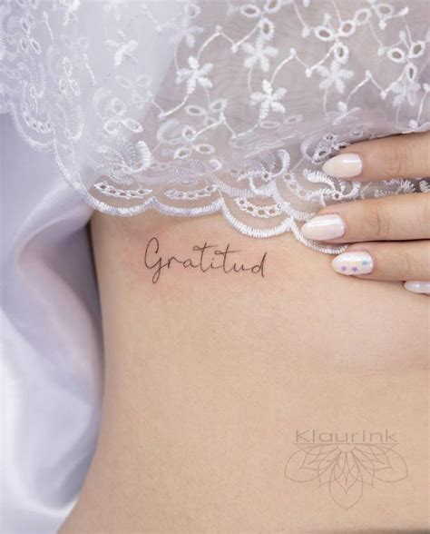 "Gratitud" lettering tattoo on the rib.