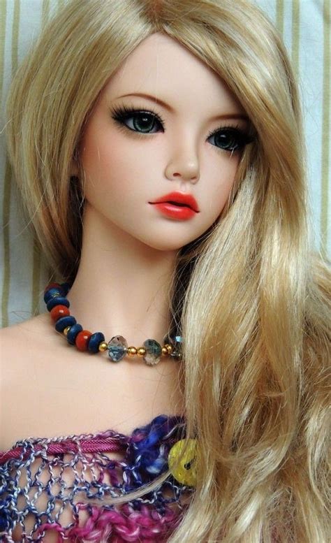 a close up of a doll with blonde hair wearing a colorful dress and ...