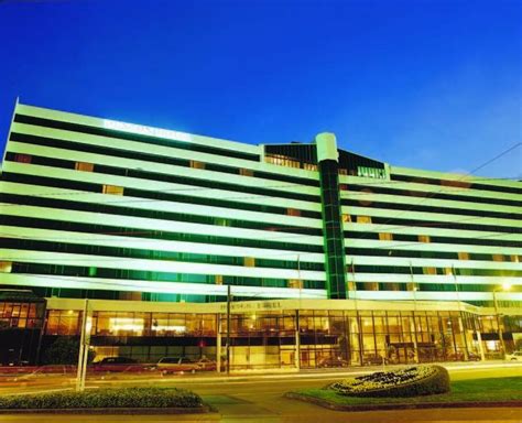 the large building has many windows and lights on it's sides at night time