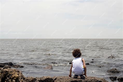 Premium Photo | Child looking at polluted river from the shore environmental concept